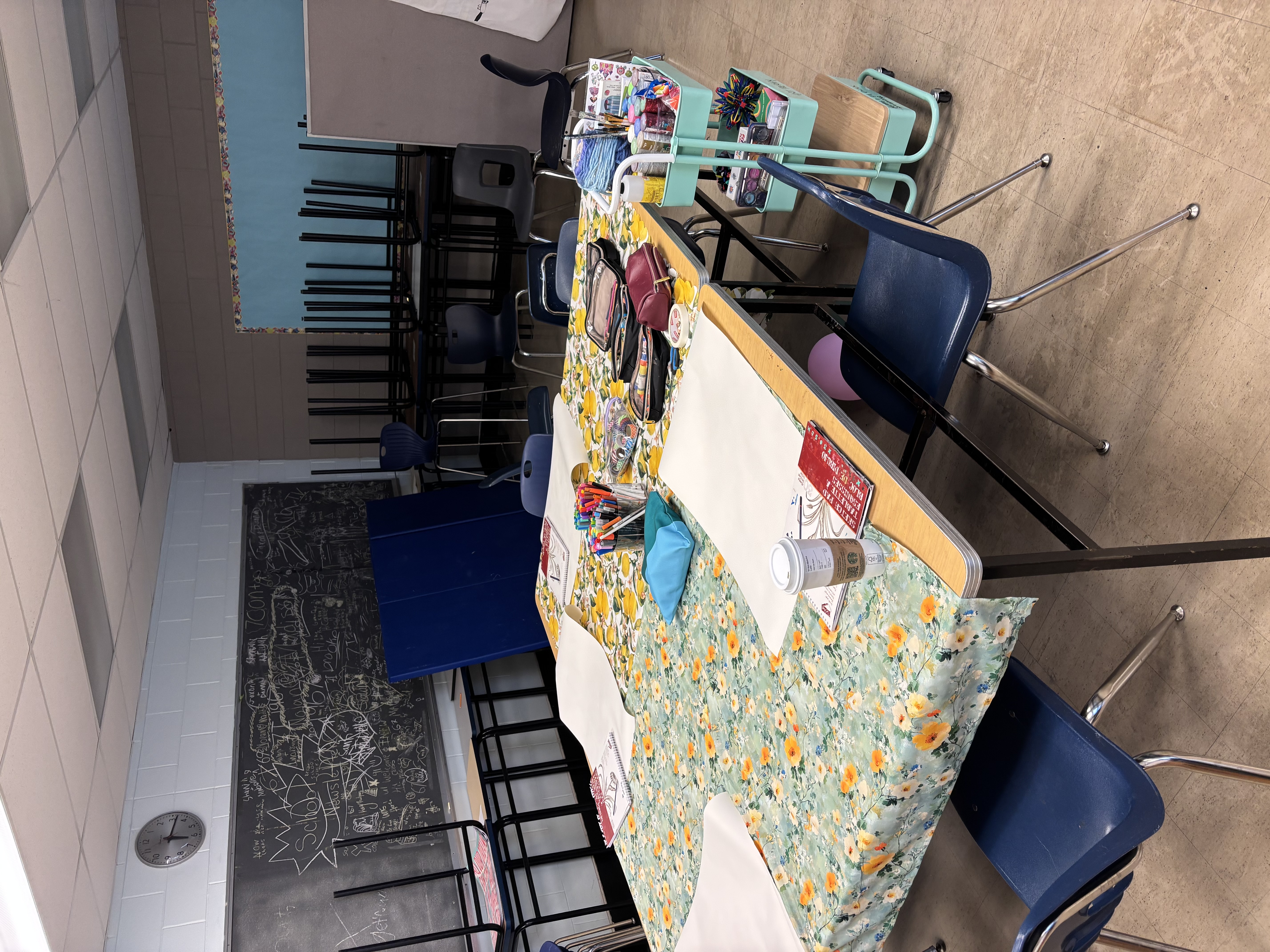 Art therapy table set with floral tablecloth, markers, and creative materials ready for students